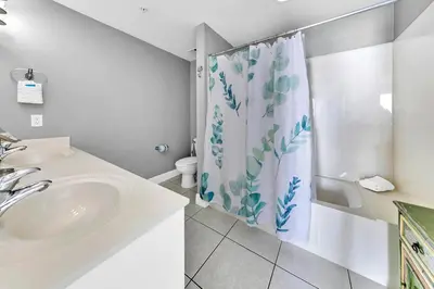 a bathroom with a sink and a shower curtain at Celadon 1902 