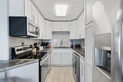 a kitchen with white cabinets and stainless steel appliances at The Summit 615 in Panama City Beach