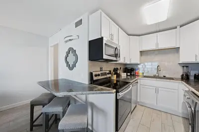 a kitchen with white cabinets and a counter top at The Summit 615 in Panama City Beach