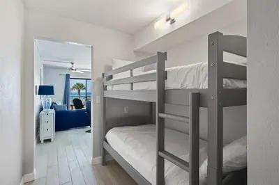 a bedroom with two bunk beds and a mirror at The Summit 220 in Panama City Beach