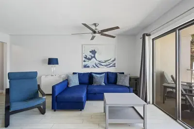 a blue couch in a living room with a ceiling fan at The Summit 220 in Panama City Beach