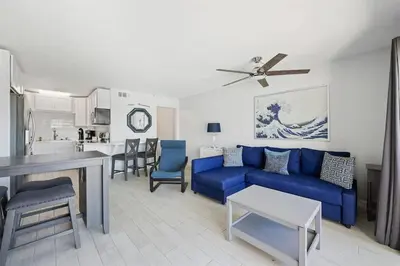 a living room with a blue couch and a kitchen at The Summit 220 in Panama City Beach