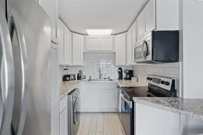 a kitchen with white cabinets and a stainless steel refrigerator at The Summit 220 in Panama City Beach