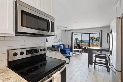 a kitchen with a microwave and a living room at The Summit 220 in Panama City Beach