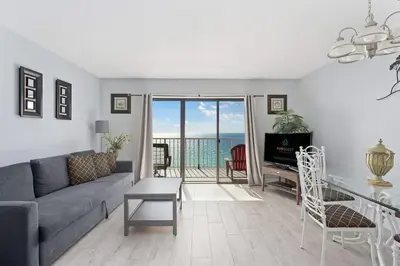 a living room with a couch and a view of the ocean at The Summit 1006 in Panama City Beach