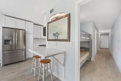 a kitchen with a counter and stools in a room at The Summit 1006 in Panama City Beach
