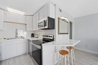 a kitchen with white cabinets and a counter top at The Summit 1006 in Panama City Beach