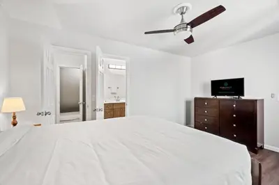 a bedroom with a white bed and a ceiling fan at 5218 Beach Dr A in Panama City Beach
