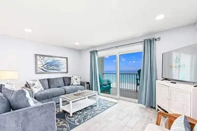 a living room with a couch and a tv at The Summit 701 in Panama City Beach