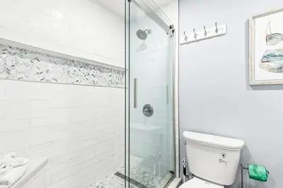 a bathroom with a toilet and a glass shower at The Summit 701 in Panama City Beach