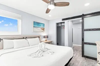 a bedroom with a white bed and a ceiling fan at The Summit 701 in Panama City Beach