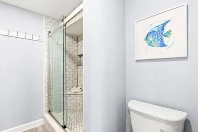 a bathroom with a toilet and a glass shower at The Summit 701 in Panama City Beach