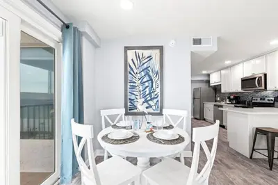 a white dining room with a white table and chairs at The Summit 701 in Panama City Beach