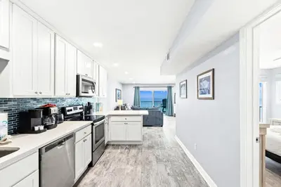 a kitchen with white cabinets and a view of the ocean at The Summit 701 in Panama City Beach