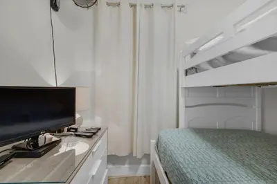 a bedroom with a bed and a flat screen tv at Brightly Furnished Beachfront Condominium by Brightwild in Panama City Beach