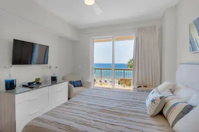 a bedroom with a bed with a view of the ocean at Brightly Furnished Beachfront Condominium by Brightwild in Panama City Beach