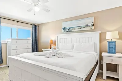 a bedroom with a white bed with a swan on it at The Summit 1011 in Panama City Beach