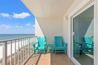a balcony with blue chairs and the ocean at The Summit 1011 in Panama City Beach