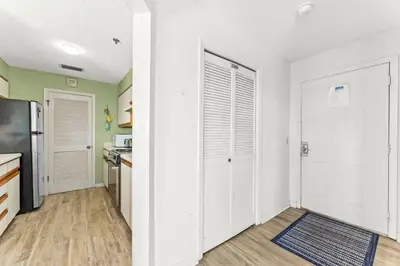 a kitchen with white cabinets and a refrigerator at 1302B St Thomas Square in Panama City Beach