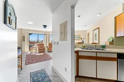 a kitchen with a sink and a living room at 1302B St Thomas Square in Panama City Beach