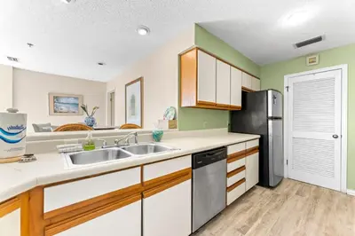 a kitchen with a sink and a refrigerator at 1302B St Thomas Square in Panama City Beach