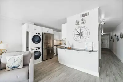 a white kitchen with a couch and a refrigerator at The Summit 602 in Panama City Beach
