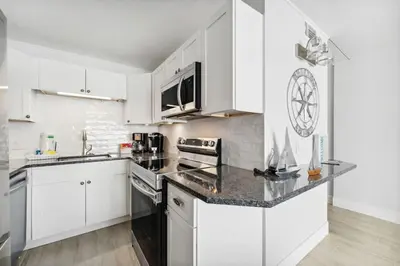 a kitchen with white cabinets and a counter top at The Summit 602 in Panama City Beach