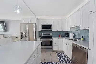 a kitchen with white cabinets and stainless steel appliances at The Summit 624 in Panama City Beach