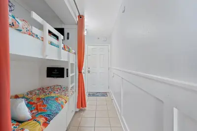 a bedroom with a bunk bed and an orange curtain at The Summit 624 in Panama City Beach