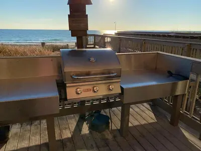 a barbecue grill sitting on a deck near the beach at Brightly Furnished Beachfront Condo by Brightwild- 7th Floor Gulf View! in Panama City Beach