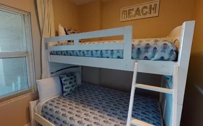 two bunk beds in a small room with a window at Brightly Furnished Beachfront Condo by Brightwild- 7th Floor Gulf View! in Panama City Beach