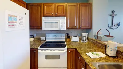 a kitchen with a white stove and a microwave at 8th Floor Gulf View Beachfront Condominium by Brightwild in Panama City Beach