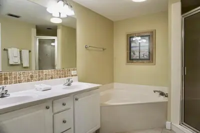 a bathroom with a tub and a sink and a bath tub at 8th Floor Gulf View Beachfront Condominium by Brightwild in Panama City Beach