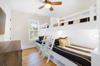 a bedroom with two bunk beds and a ceiling fan at Calm Breeze Cottage in Santa Rosa Beach