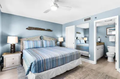 a bedroom with a bed and a mirror at Commodore 903 (2/2) in Panama City Beach