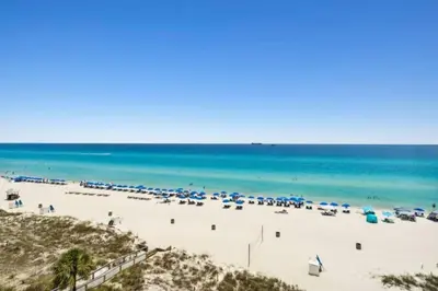 a beach with a lot of umbrellas and the ocean at Commodore 903 (2/2) in Panama City Beach