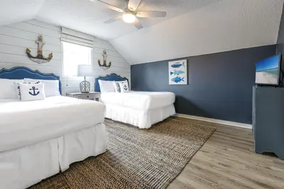 a bedroom with two beds and a blue wall at Cassine Dream in Santa Rosa Beach