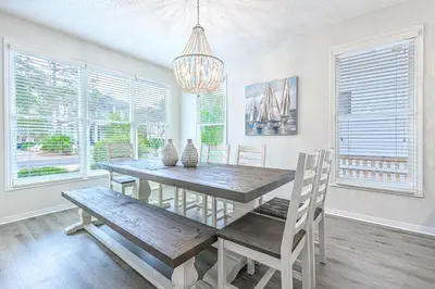 a dining room with a wooden table and a chandelier at Cassine Dream in Santa Rosa Beach