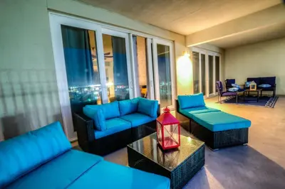 a living room with blue furniture and a large window at BRAND NEW!Laketown Wharf 334! Beautiful 3 BD, Great Amenities, And Great Location in Panama City Beach