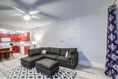 a living room with a couch and a brick wall at BRAND NEW!Laketown Wharf 334! Beautiful 3 BD, Great Amenities, And Great Location in Panama City Beach
