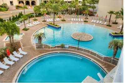 an overhead view of a large swimming pool with white chairs at BRAND NEW!Laketown Wharf 334! Beautiful 3 BD, Great Amenities, And Great Location in Panama City Beach