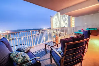 a balcony with two chairs and a couch and a table at BRAND NEW!Laketown Wharf 233! Beautiful 3 BD, Great Amenities, And Great Location in Panama City Beach