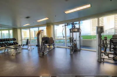 a gym with several treadmills and chairs and windows at BRAND NEW!Laketown Wharf 233! Beautiful 3 BD, Great Amenities, And Great Location in Panama City Beach