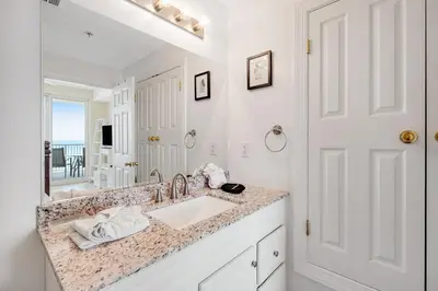 a white bathroom with a sink and a mirror at Fantastic Private Complex -Beachfront 2BD Ocean Villa! Gorgeous Amenities in Panama City Beach