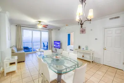 a living room with a glass table and chairs at Fantastic Private Complex -Beachfront 2BD Ocean Villa! Gorgeous Amenities in Panama City Beach