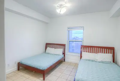 two beds in a room with a window at Fantastic Private Complex -Beachfront 2BD Ocean Villa! Gorgeous Amenities in Panama City Beach