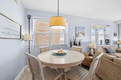 a living room with a table and a couch at Waterfront PCB Condo with Balcony and Beach Gear! in Panama City Beach