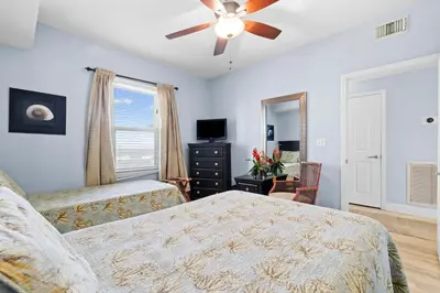 a bedroom with a bed and a ceiling fan at Waterfront PCB Condo with Balcony and Beach Gear! in Panama City Beach