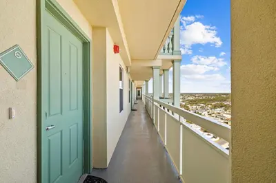 a corridor of a building with a green door at Waterfront PCB Condo with Balcony and Beach Gear! in Panama City Beach