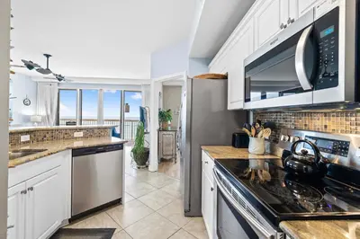 a kitchen with a sink and a stove top oven at Waterfront PCB Condo with Balcony and Beach Gear! in Panama City Beach